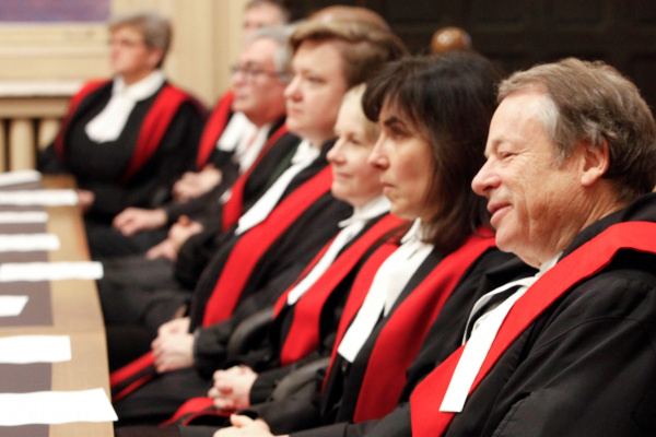 Judges in their judicial robes sitting in a row in a courtroom. 