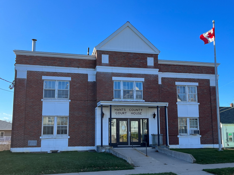 Brick building with a white roof and a Canada flag out front.