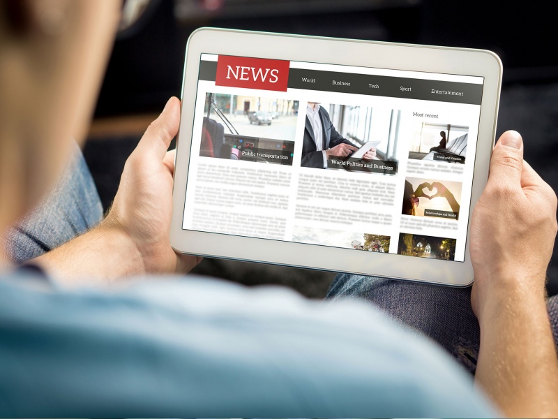 Man reading a news story on a tablet. 