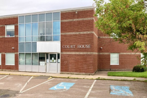 Large red brick building with glass windows surrounding the front entrance.