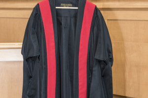 Black and red judicial robes hanging on a hook.