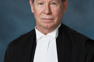 White man in black and white judicial robes. 